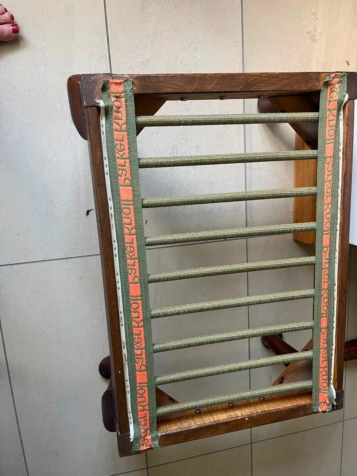 Underside of the matching footstool frame with new webbing stretched across